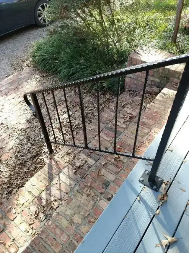 Wrought iron handrail built for a brick porch step