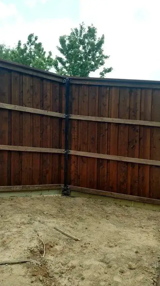 Stained board on board wood privacy fence corner in a backyard, clean finish